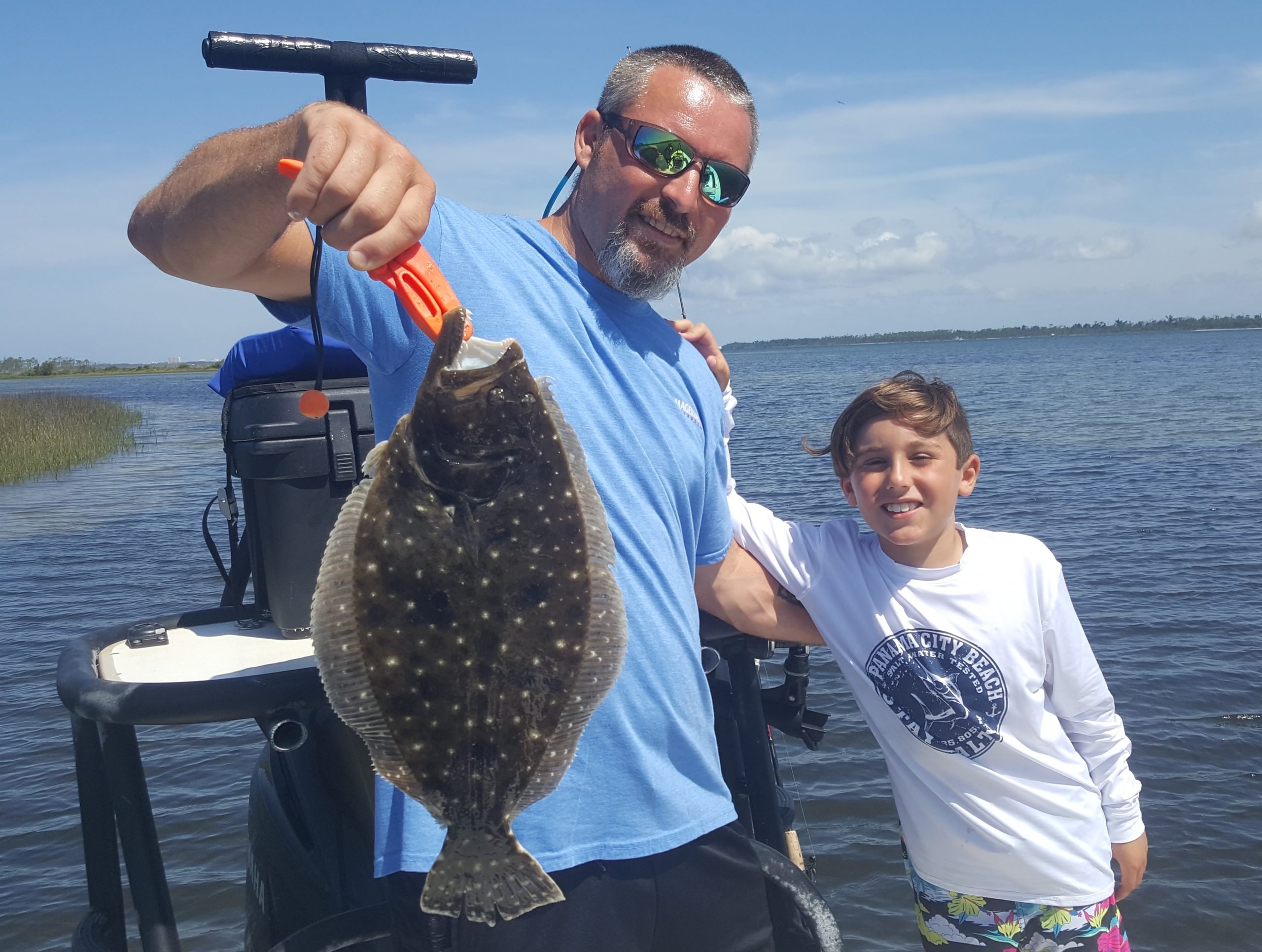 Flounder Fishing catch charter fishing client holding a fish and getting some Flounder Fishing in at panama city