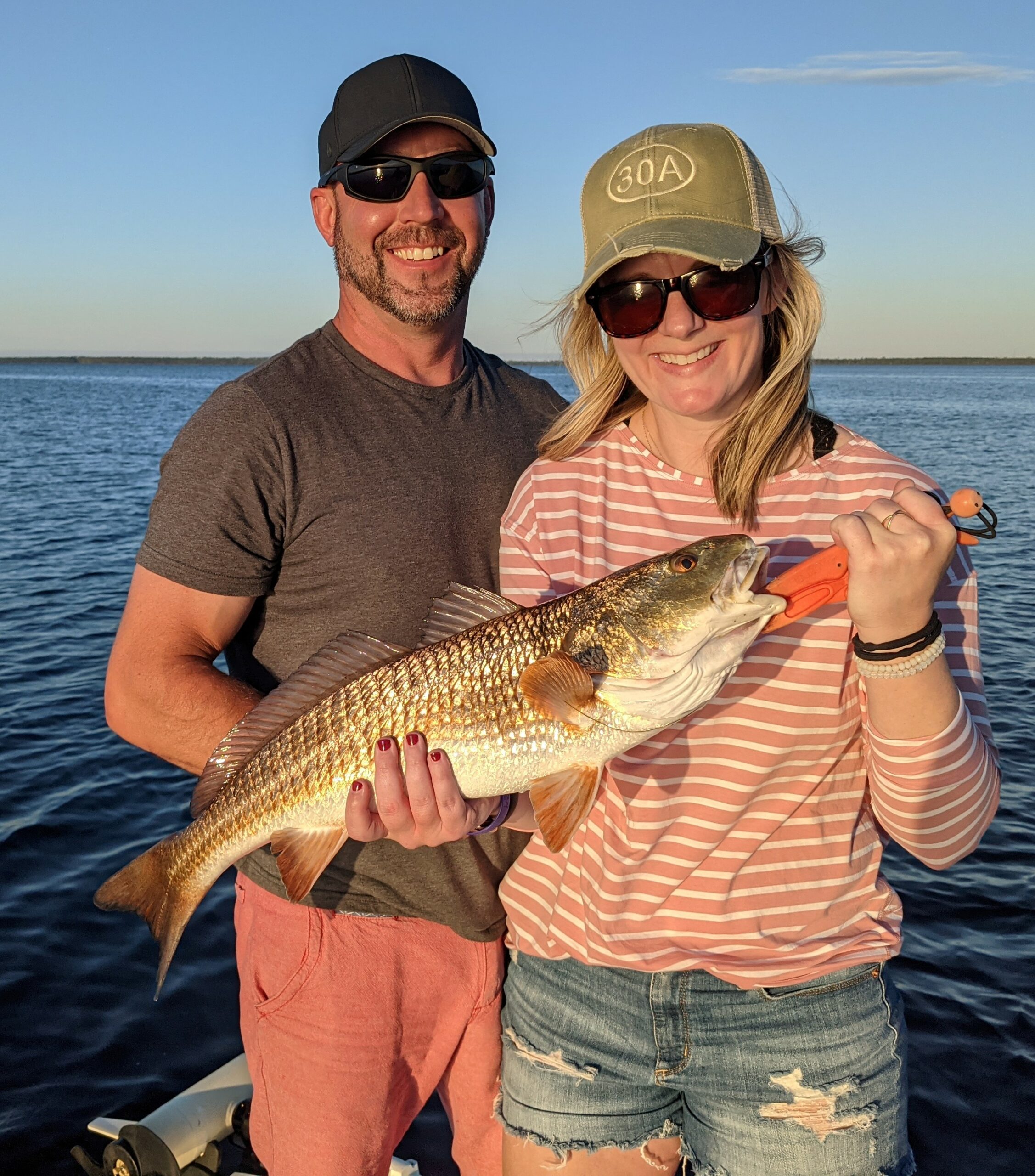 Jack Crevelle Fishing catch charter fishing client holding a fish and getting some Jack Crevelle Fishing in at panama city