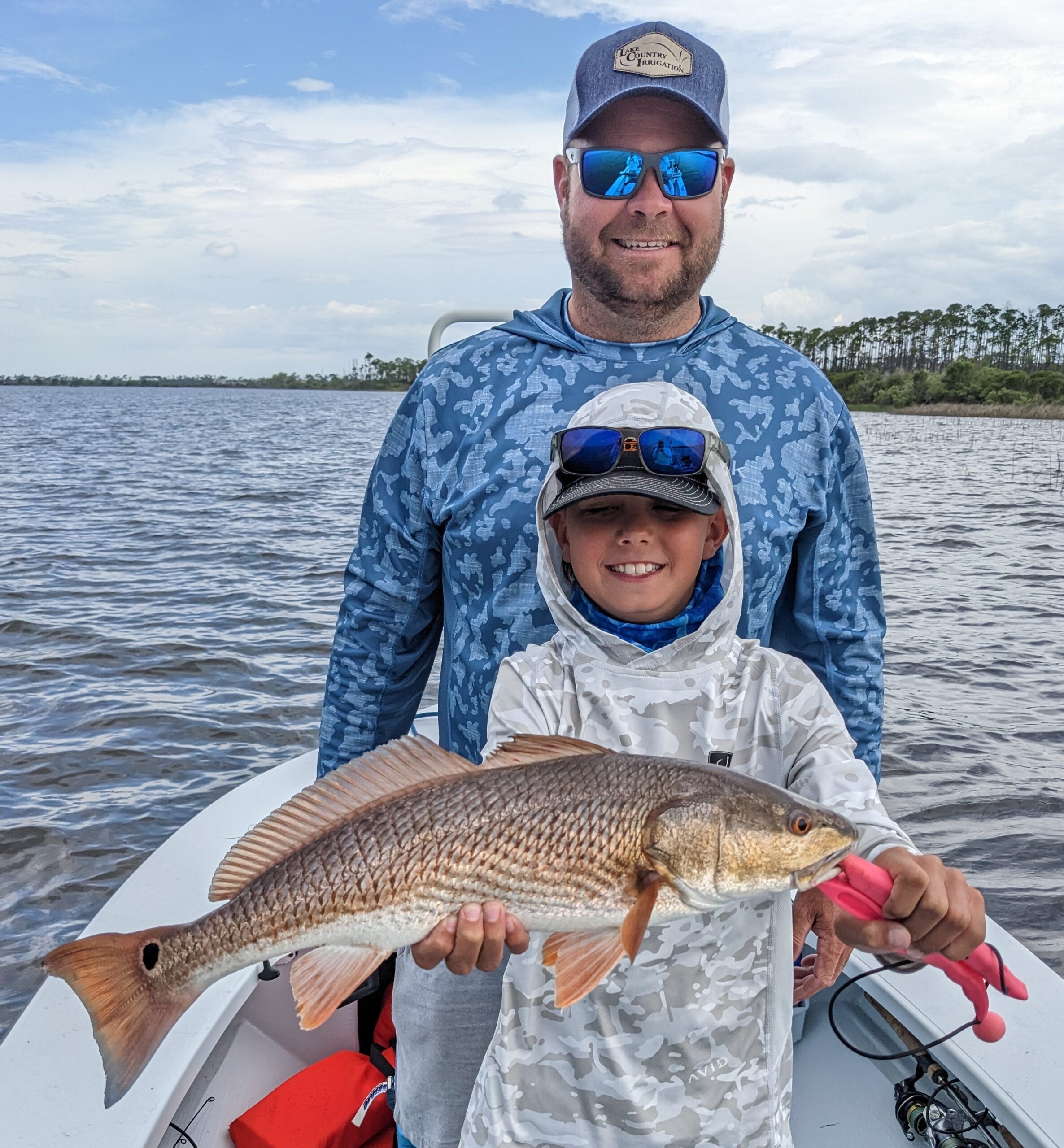 Kids Fishing catch charter fishing client holding a fish and getting some Kids Fishing in at panama city