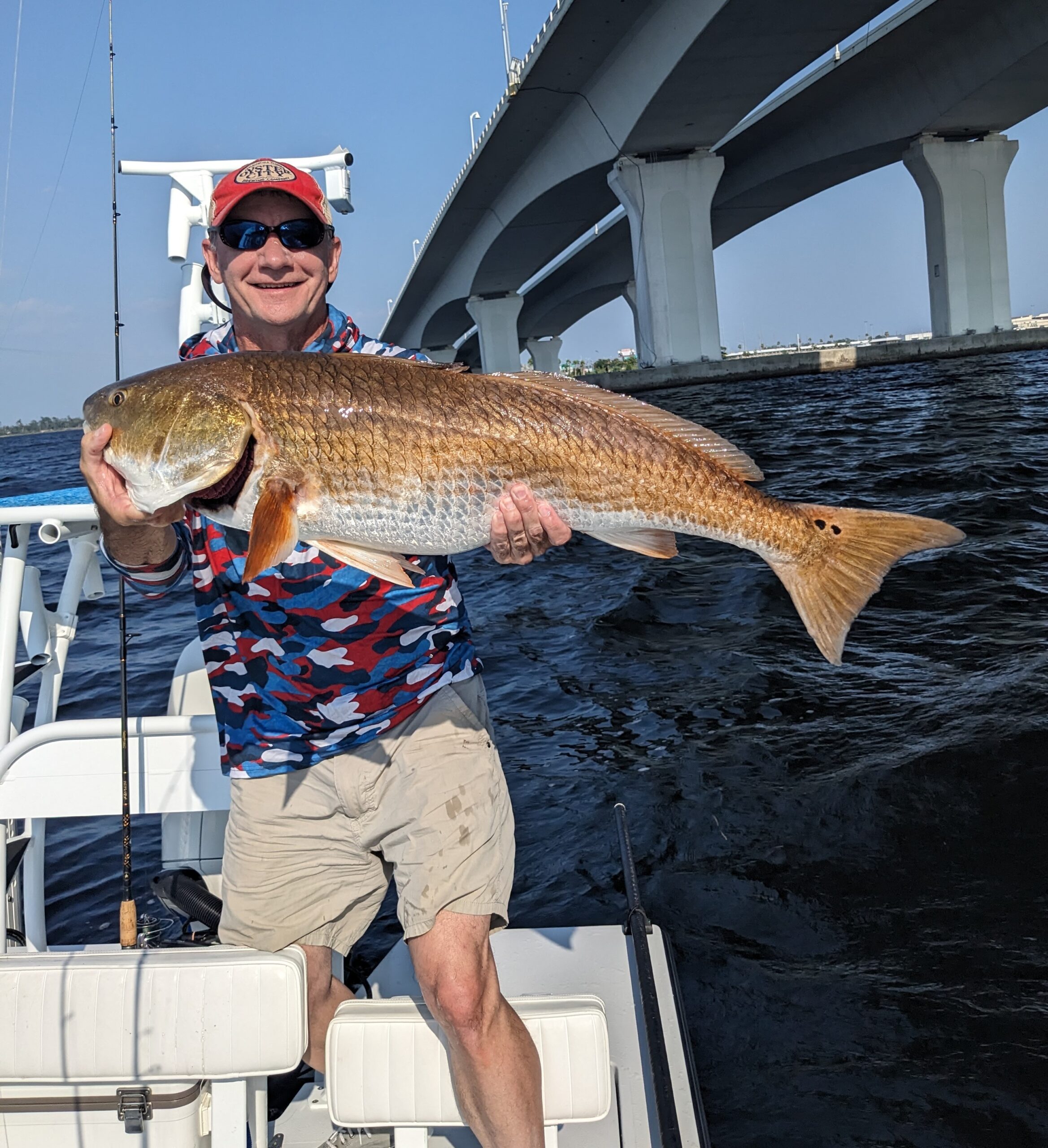Red Fishing catch charter fishing client holding a fish and getting some Red Fishing in at panama city